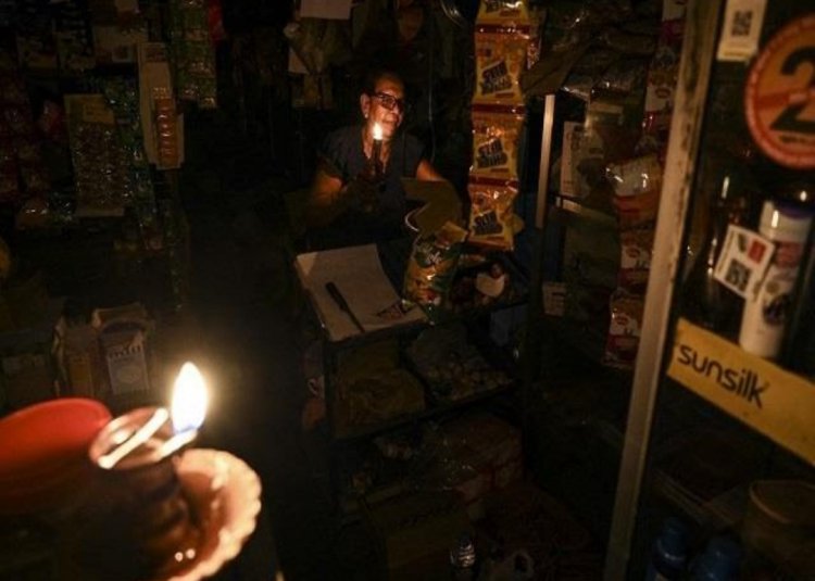 बिजली संकट के चलते बांग्लादेश में  मोमबत्तियां जलाकर काम चला रहे दुकानदार